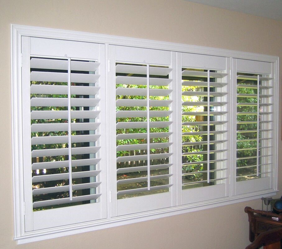 White window blinds on a row of windows in a living room